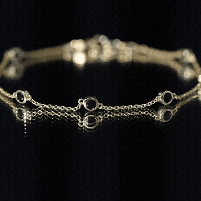 Bezel set black onyx seven-stone station chain bracelet by Rosec Jewels featuring alternating black gemstones and a gold chain.