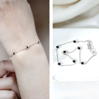 Bezel set black onyx seven-stone station chain bracelet by Rosec Jewels showing a silver bracelet with black onyx stones.
