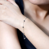 Bezel set black onyx seven-stone station bracelet by Rosec Jewels featuring a delicate chain and polished onyx stones.