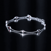 Bezel set garnet seven-stone station chain bracelet by Rosec Jewels featuring vibrant red gemstones and gold-tone links.