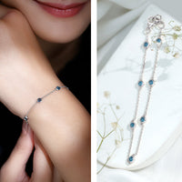 Bezel set London Blue Topaz station chain bracelet by Rosec Jewels with faceted blue gemstones and silver-tone chain links.