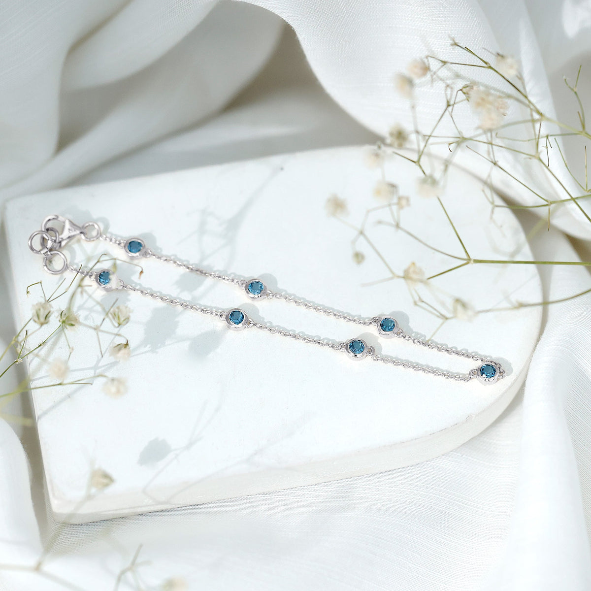 Bezel set London Blue Topaz station chain bracelet by Rosec Jewels, featuring elegant blue gemstones on a delicate silver chain.