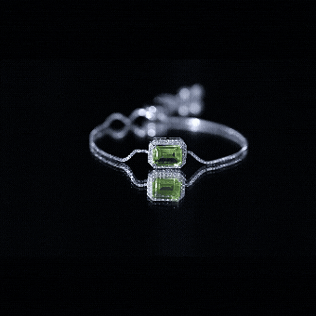 Emerald cut peridot and diamond bolo chain bracelet with yellow gold finish, featuring sparkling gemstones and elegant design.