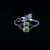Emerald cut peridot and diamond bolo chain bracelet with yellow gold finish, featuring sparkling gemstones and elegant design.