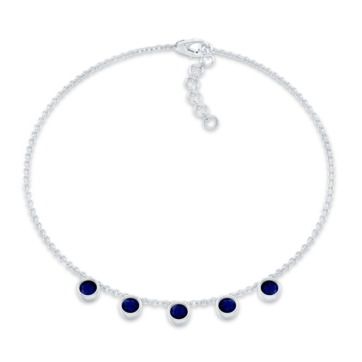 Bezel set blue sapphire charm bracelet by Rosec Jewels featuring a delicate silver chain with blue sapphire gemstones.