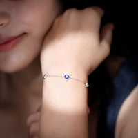 Bezel set fire opal evil eye station bracelet for women by Rosec Jewels, featuring vibrant orange and blue gemstone charms.