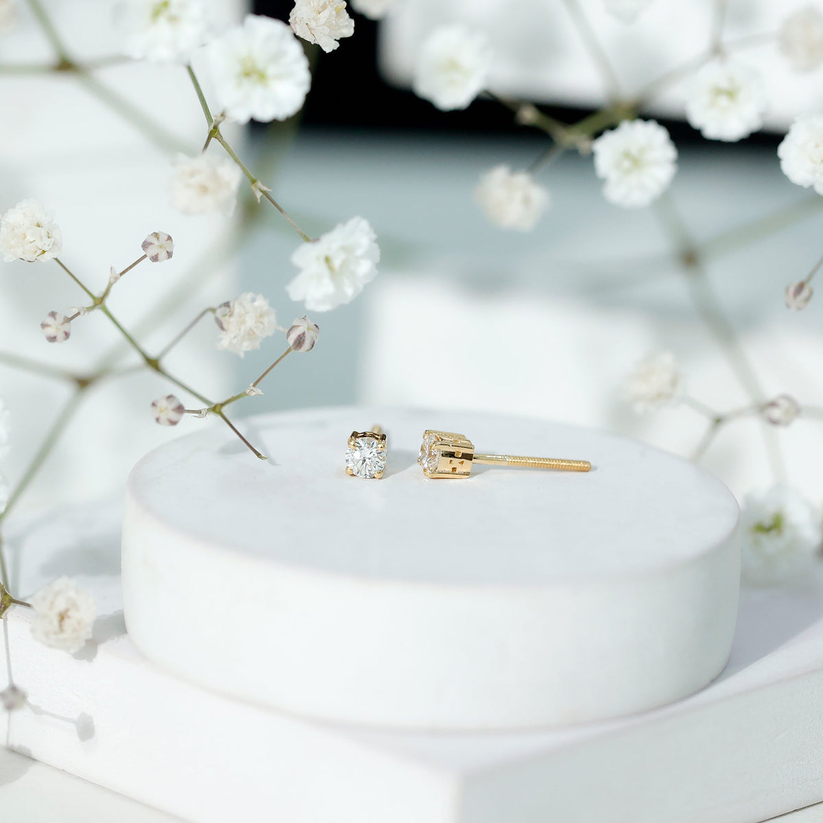 Brilliant cut diamond stud earrings in prong setting by Rosec Jewels, showcasing sparkling diamonds on a sleek metal background.