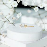 Brilliant cut diamond stud earrings in prong setting by Rosec Jewels, showcasing sparkling diamonds on a sleek metal background.