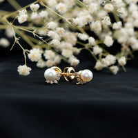 Rosec Jewels modern stud earrings featuring freshwater pearl and diamond accents, close-up view of elegant jewelry design.