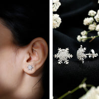 Rosec Jewels certified moissanite winter snowflake stud earrings with sparkling snowflake design on a white background.