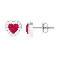 Heart-shaped ruby stud earrings with diamond halo from Rosec Jewels, featuring vibrant red rubies and sparkling diamond accents.