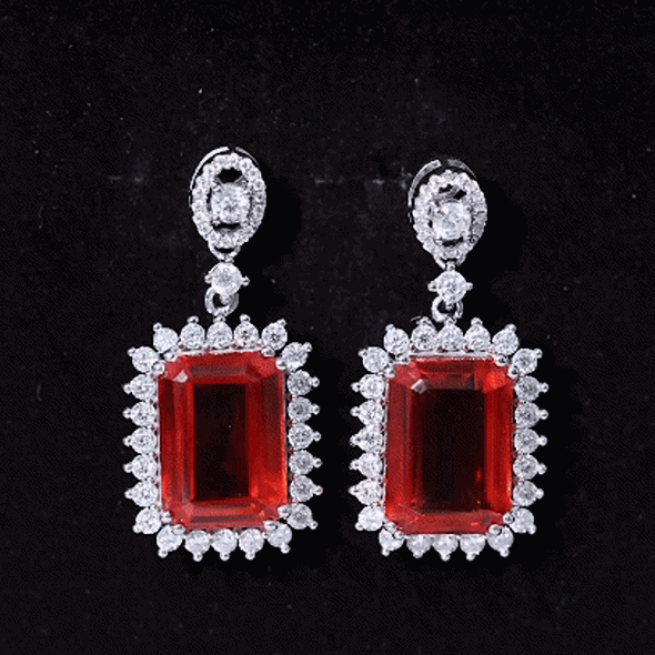 Certified 18 carat lab-grown orange sapphire statement earrings in silver with intricate design.