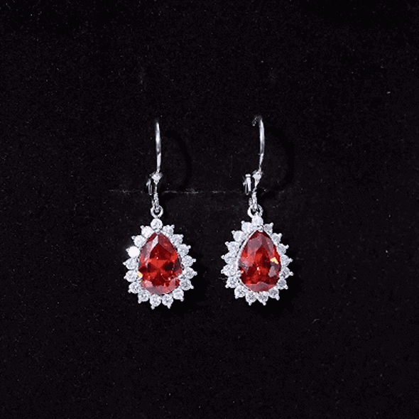 Orange sapphire teardrop earrings with moissanite halo accents, featuring 5 carats total weight, from Rosec Jewels.