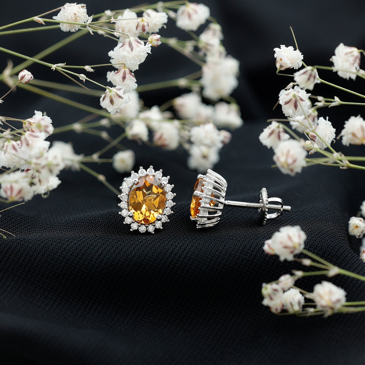 Natural 6x8mm oval citrine stud earrings with halo setting from Rosec Jewels, showcasing sparkling yellow gemstones.
