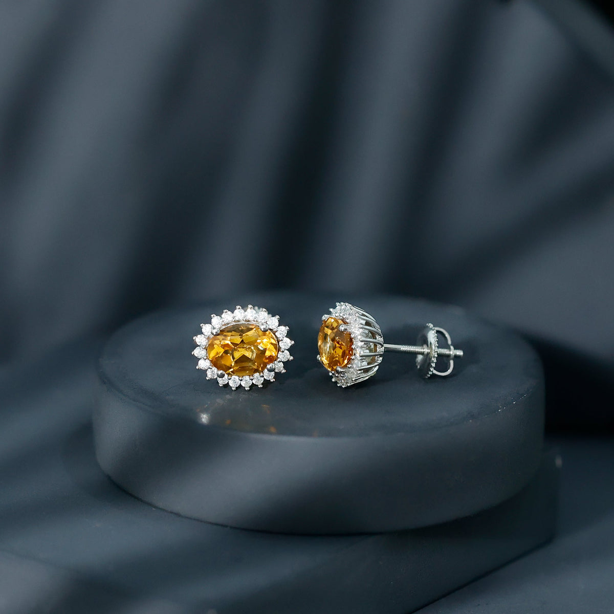 Natural 6x8mm oval citrine stud earrings with halo setting by Rosec Jewels, showcasing the sparkling yellow gemstones.