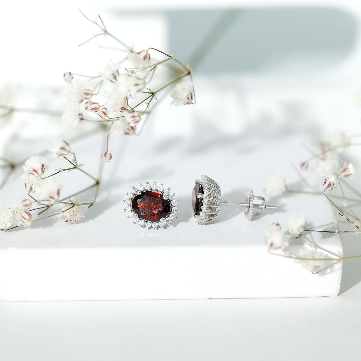 3 Carat garnet oval stud earrings with moissanite halo, featuring rose gold finish and elegant gemstone setting.