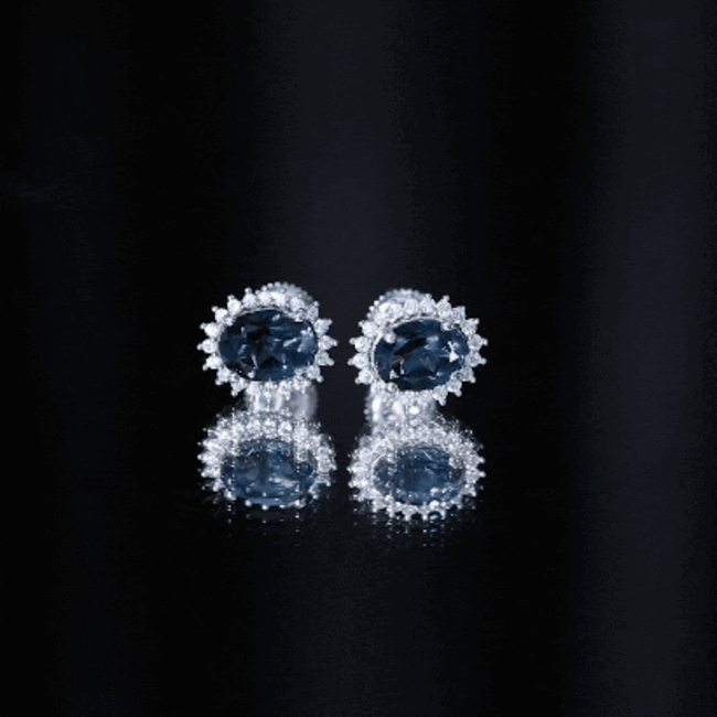 Rosec Jewels 6x8mm oval London Blue Topaz stud earrings with moissanite halo, showcasing sparkling blue gemstones and radiant design.