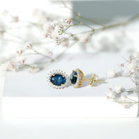 Oval London Blue Topaz stud earrings with moissanite halo, featuring 6x8mm gemstones and Rosec Jewels branding.