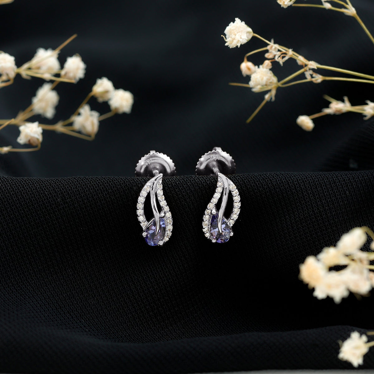 Pear shape tanzanite and diamond leaf stud earrings in gold, featuring elegant gemstone and sparkle details by Rosec Jewels.