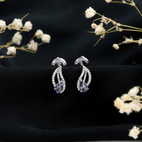 Pear shape tanzanite and diamond leaf stud earrings in gold, featuring elegant gemstone and sparkle details by Rosec Jewels.