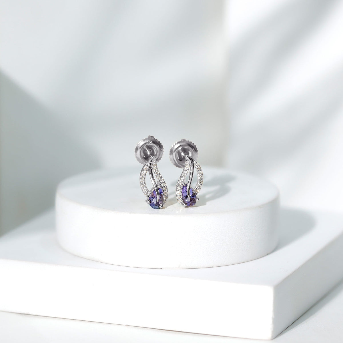 Pear-shaped Tanzanite and diamond leaf stud earrings by Rosec Jewels, featuring elegant gemstone and diamond accents.