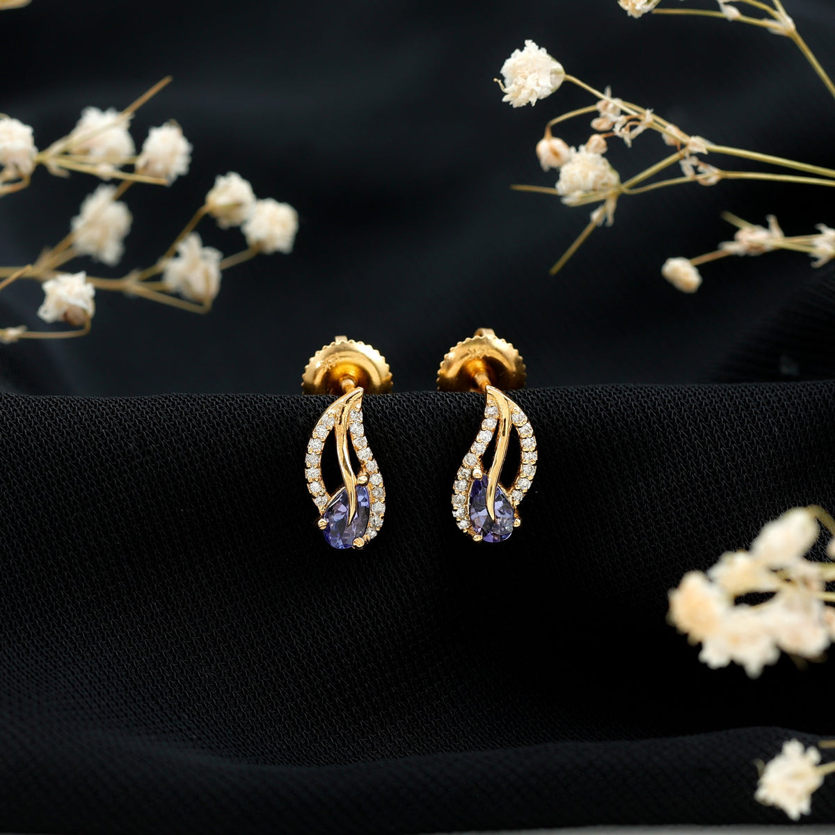Pear-shaped tanzanite and diamond leaf stud earrings in gold, featuring elegant, nature-inspired design by Rosec Jewels.