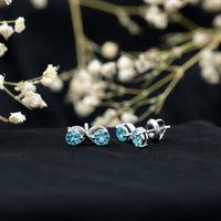 Rosec Jewels real aquamarine infinity stud earrings featuring sparkling blue gemstones and sleek silver settings.