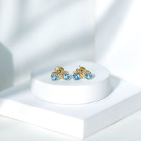 Rosec Jewels real aquamarine infinity stud earrings featuring sparkling blue aquamarine stones on silver posts.