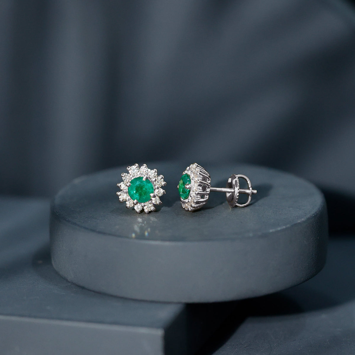 Rosec Jewels classic emerald stud earrings with diamond halo, featuring sparkling green gemstones and elegant metallic setting