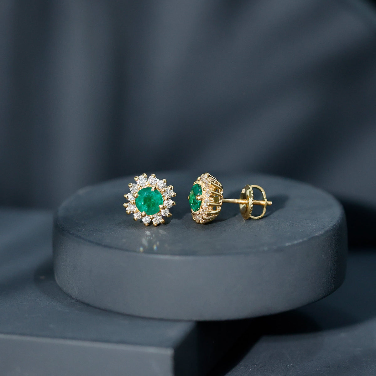 Rosec Jewels classic emerald stud earrings with diamond halo, featuring vibrant green emeralds and sparkling diamonds.