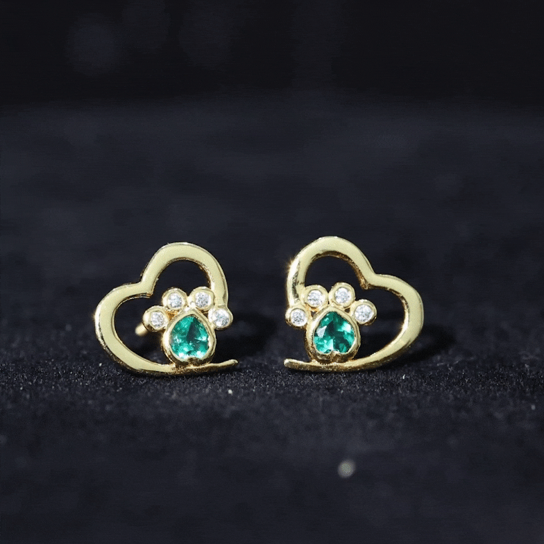 Lab-created emerald and moissanite heart paw stud earrings with yellow accents, featuring sparkling gemstones and delicate design.