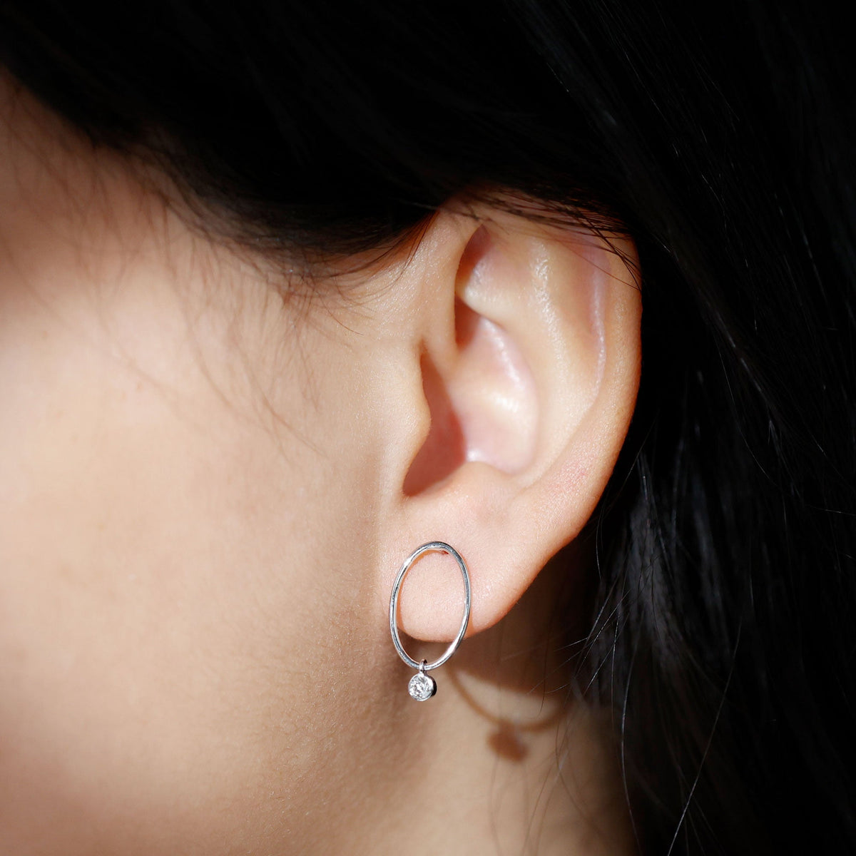 Rosec Jewels Bezel set Moissanite front-facing hoop drop earrings with sparkling stones on a white background.