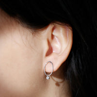 Rosec Jewels Bezel set Moissanite front-facing hoop drop earrings with sparkling stones on a white background.