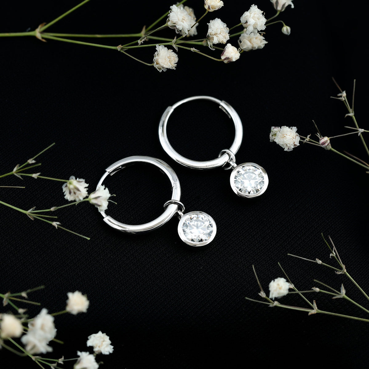 Rosec Jewels bezel set moissanite hinged hoop earrings, showcasing sparkling gemstones and polished metal finish.