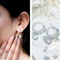Bezel set 2 carat round moissanite drop hoop earrings by Rosec Jewels, featuring sparkling moissanite stones in a stylish hoop design.