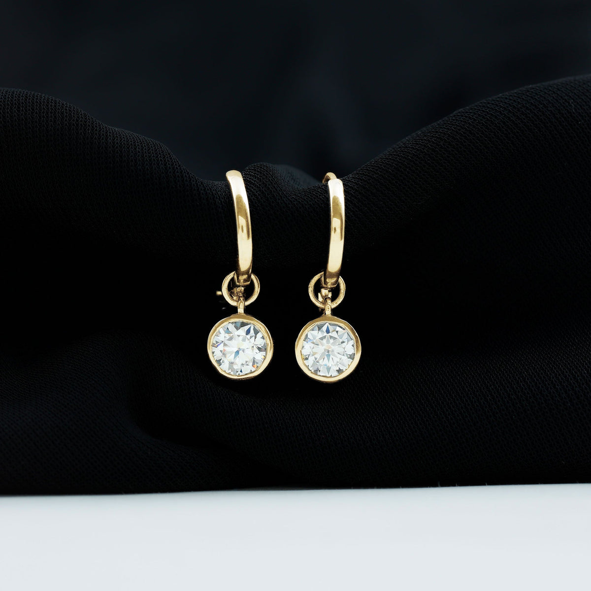 Bezel set moissanite and hinged hoop earrings by Rosec Jewels, showcasing sparkling stones and sleek gold design.
