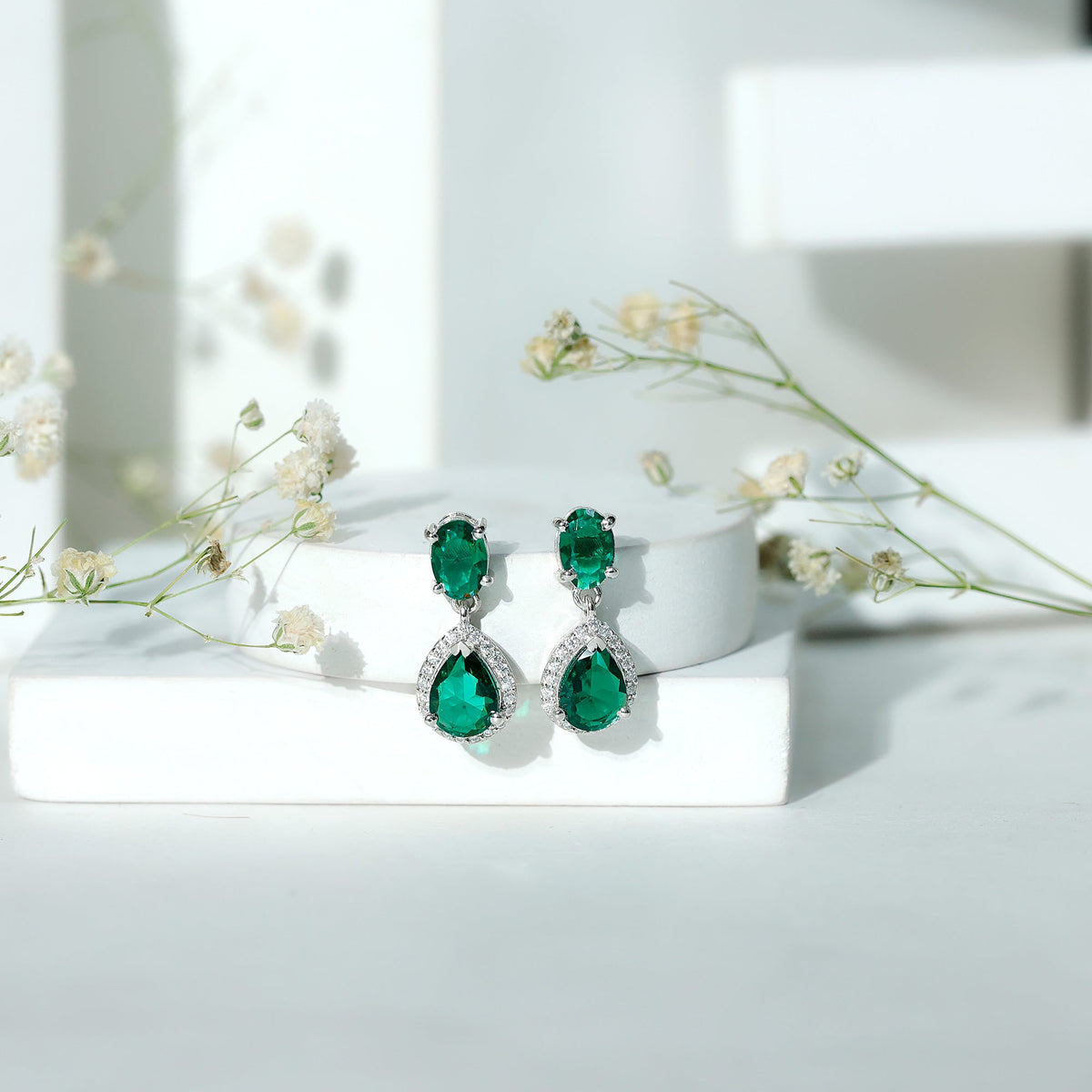 Lab-created emerald and moissanite dangle earrings by Rosec Jewels featuring classic, elegant design with sparkling gemstones.