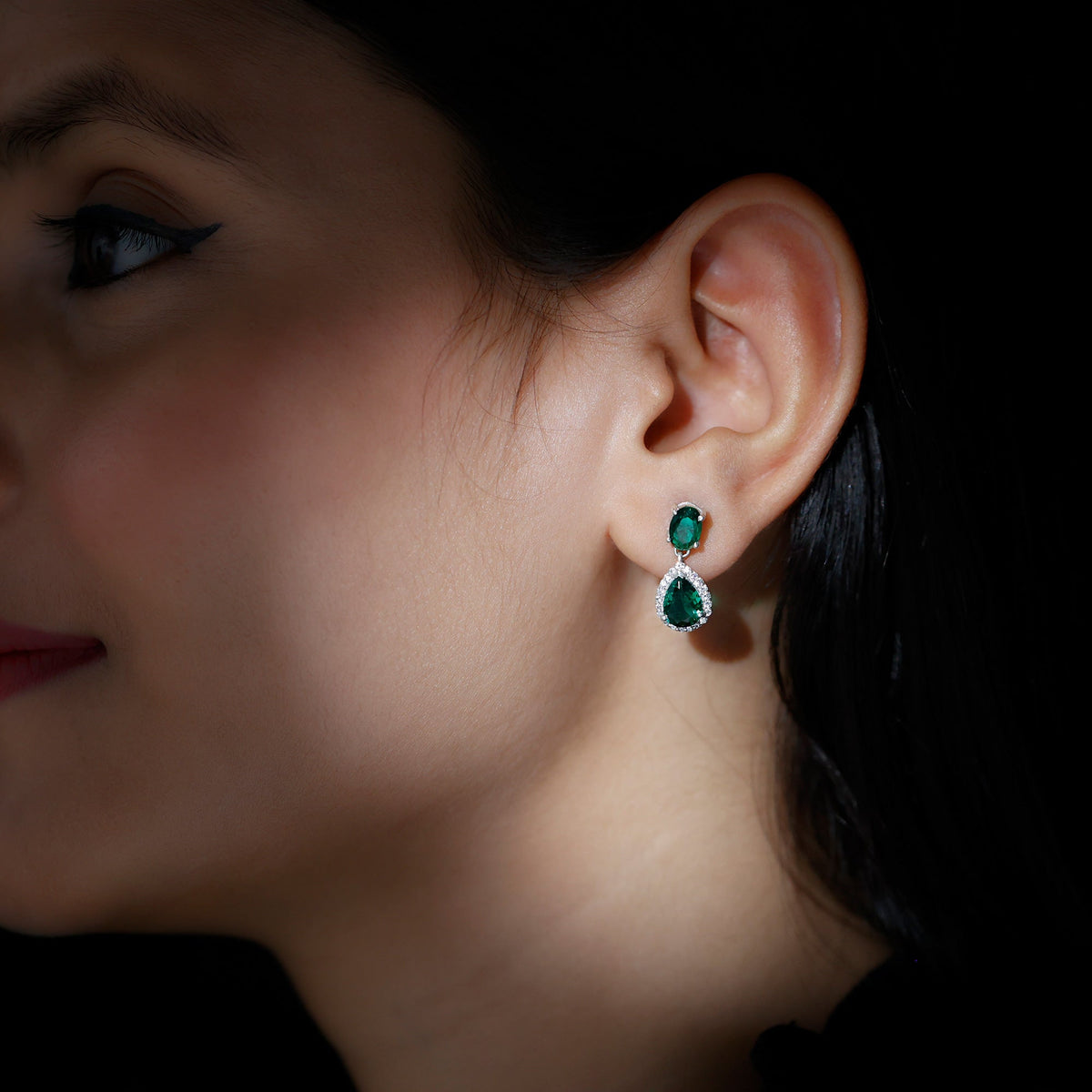 Lab-created emerald dangle earrings with moissanite accents, crafted by Rosec Jewels, featuring elegant gemstone design.