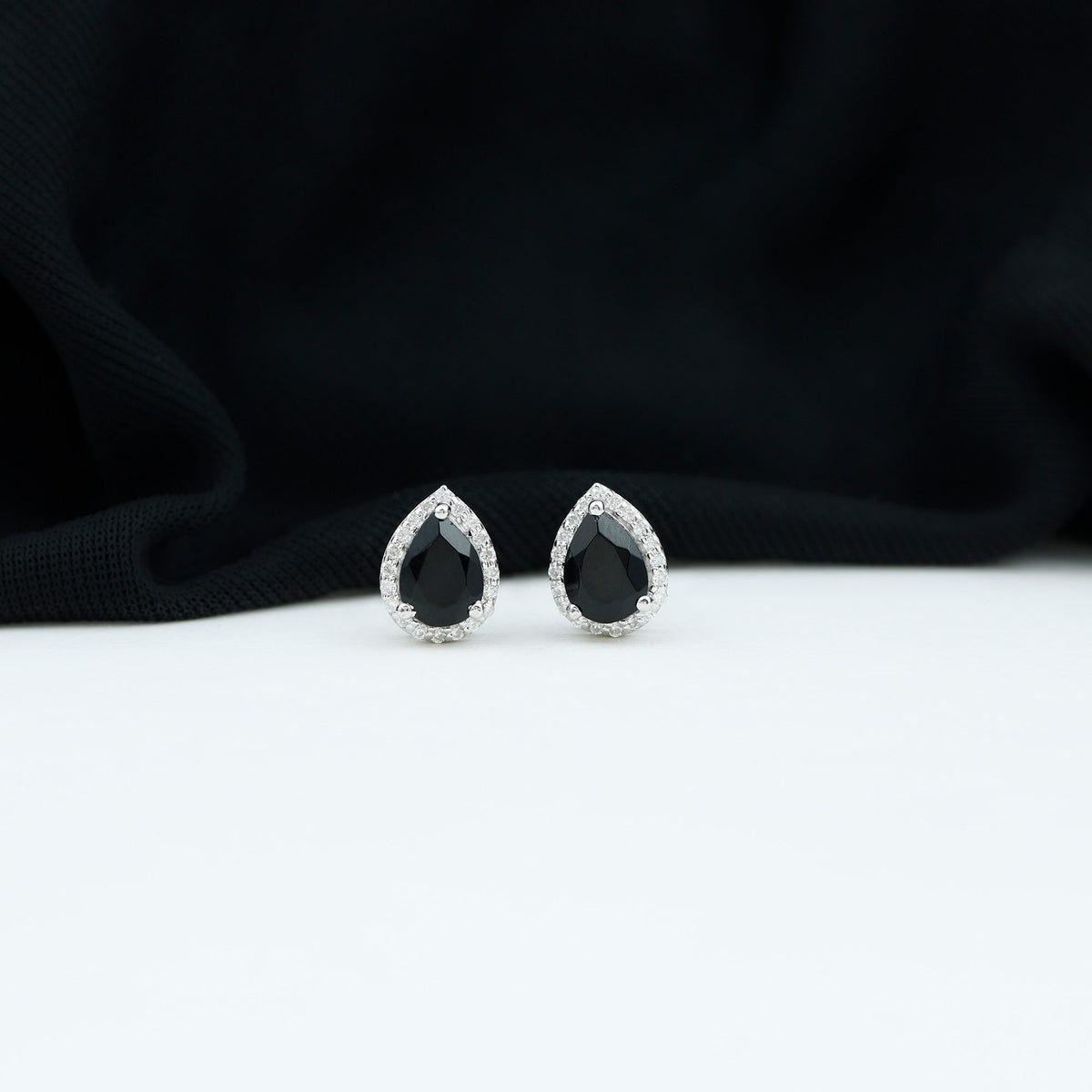 Natural 5x7 mm pear-shaped black spinel earrings with diamond halo by Rosec Jewels, showcasing elegant jewelry design.