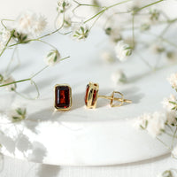 Emerald cut 1.4 CT garnet solitaire stud earrings in bezel setting by Rosec Jewels, showcasing elegant gemstone jewelry.