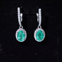 Oval emerald hoop earrings with diamond halo by Rosec Jewels, showcasing yellow gold earrings with sparkling gemstone accents.