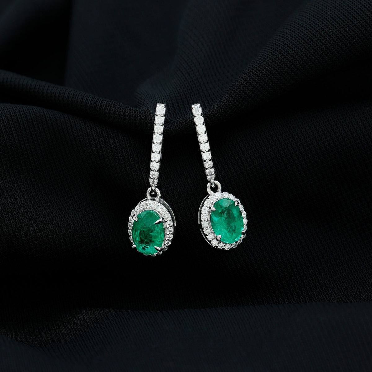 Oval shape emerald hoop drop earrings with diamond halo featuring green gemstones and sparkling accents by Rosec Jewels