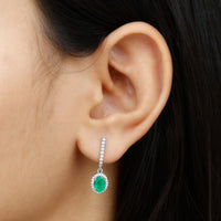 Oval emerald hoop earrings with diamond halo by Rosec Jewels, featuring elegant drop design and sparkling gemstone accents.