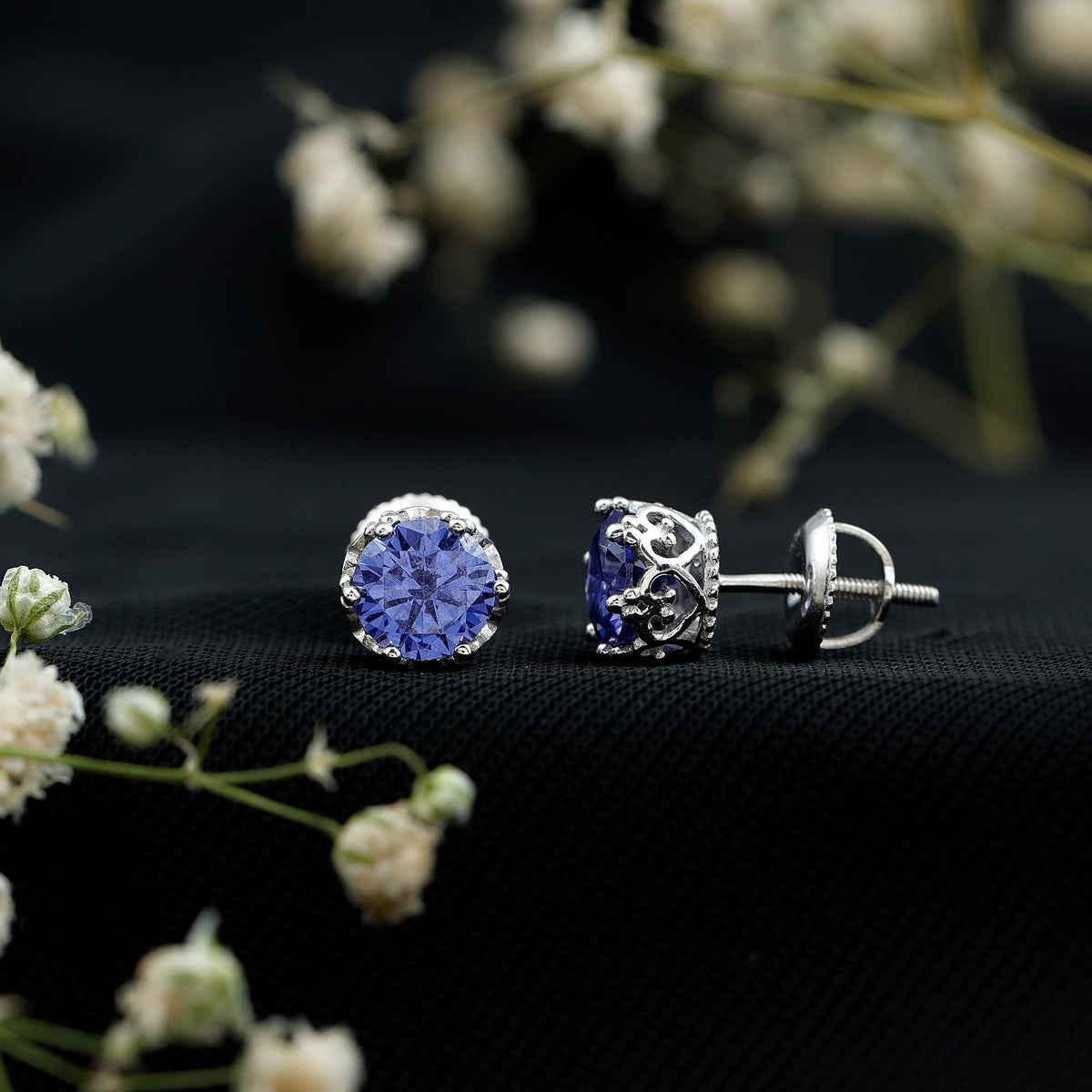Created blue sapphire solitaire crown stud earrings by Rosec Jewels, showcasing sparkling blue gemstones in a classic setting.