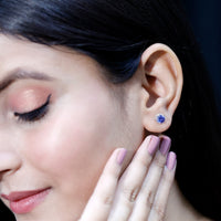Two blue sapphire solitaire crown stud earrings by Rosec Jewels featuring created blue sapphires in a classic earring style.