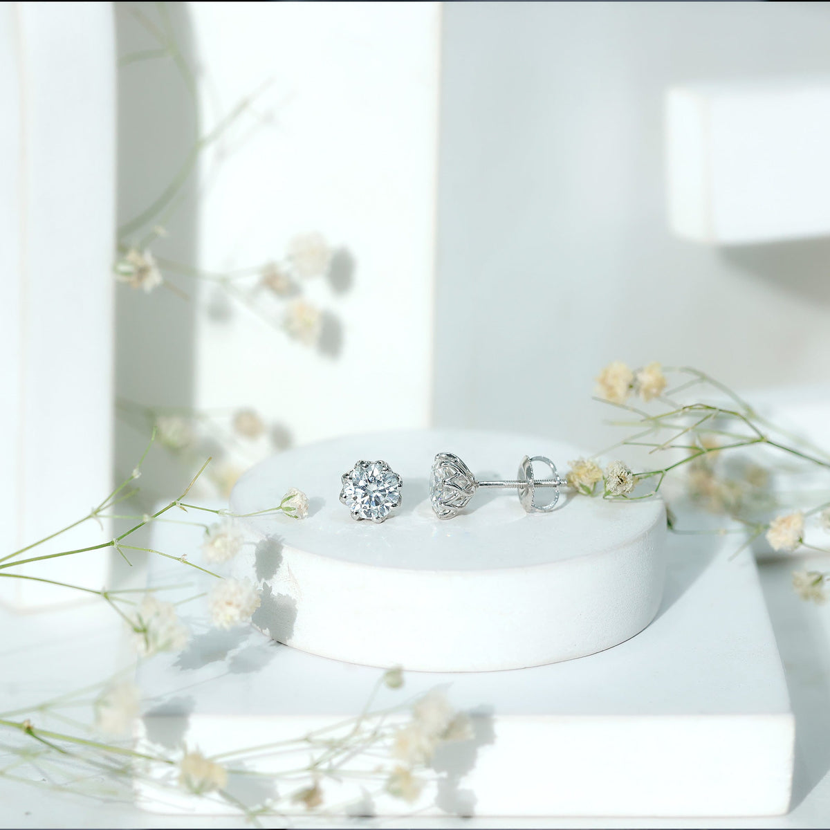 Certified 1.9 Carat Moissanite Solitaire Stud Earrings by Rosec Jewels with brilliant cut gemstones on a white background.