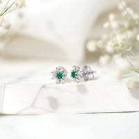 Natural emerald and diamond floral stud earrings from Rosec Jewels featuring vibrant green gemstones and sparkling accents.