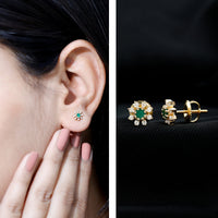 Natural emerald and diamond floral stud earrings by Rosec Jewels featuring detailed gemstone settings and elegant design.