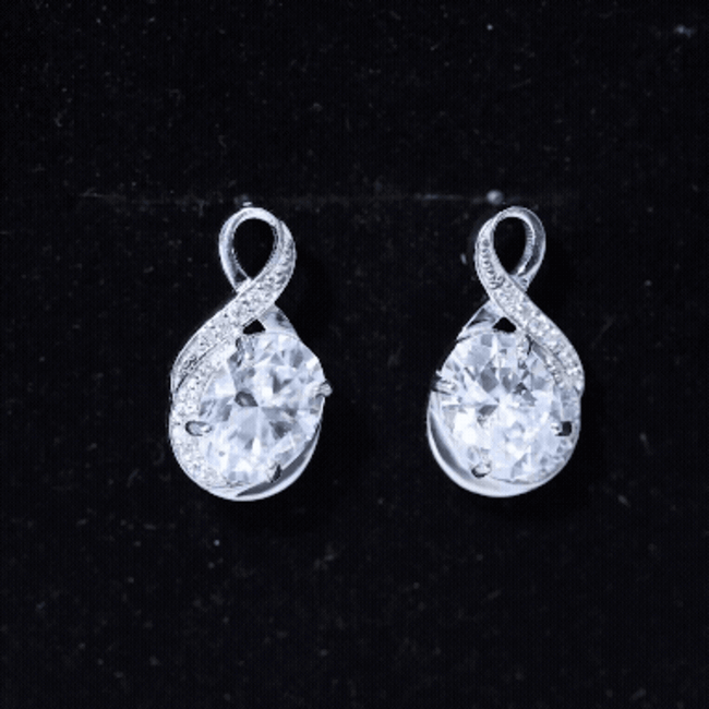 Silver 4-carat oval cut Moissanite infinity stud earrings by Rosec Jewels, showcasing sparkling gemstone designs on a white background.