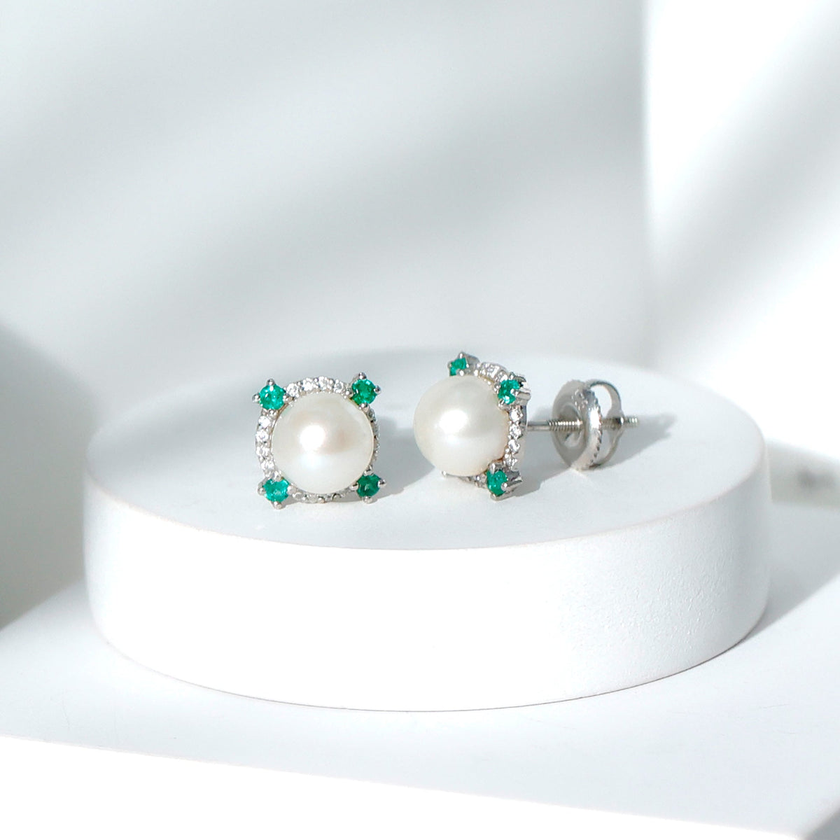 Freshwater pearl bridal stud earrings with emerald accents by Rosec Jewels, showcasing elegant pearl and gemstone details.